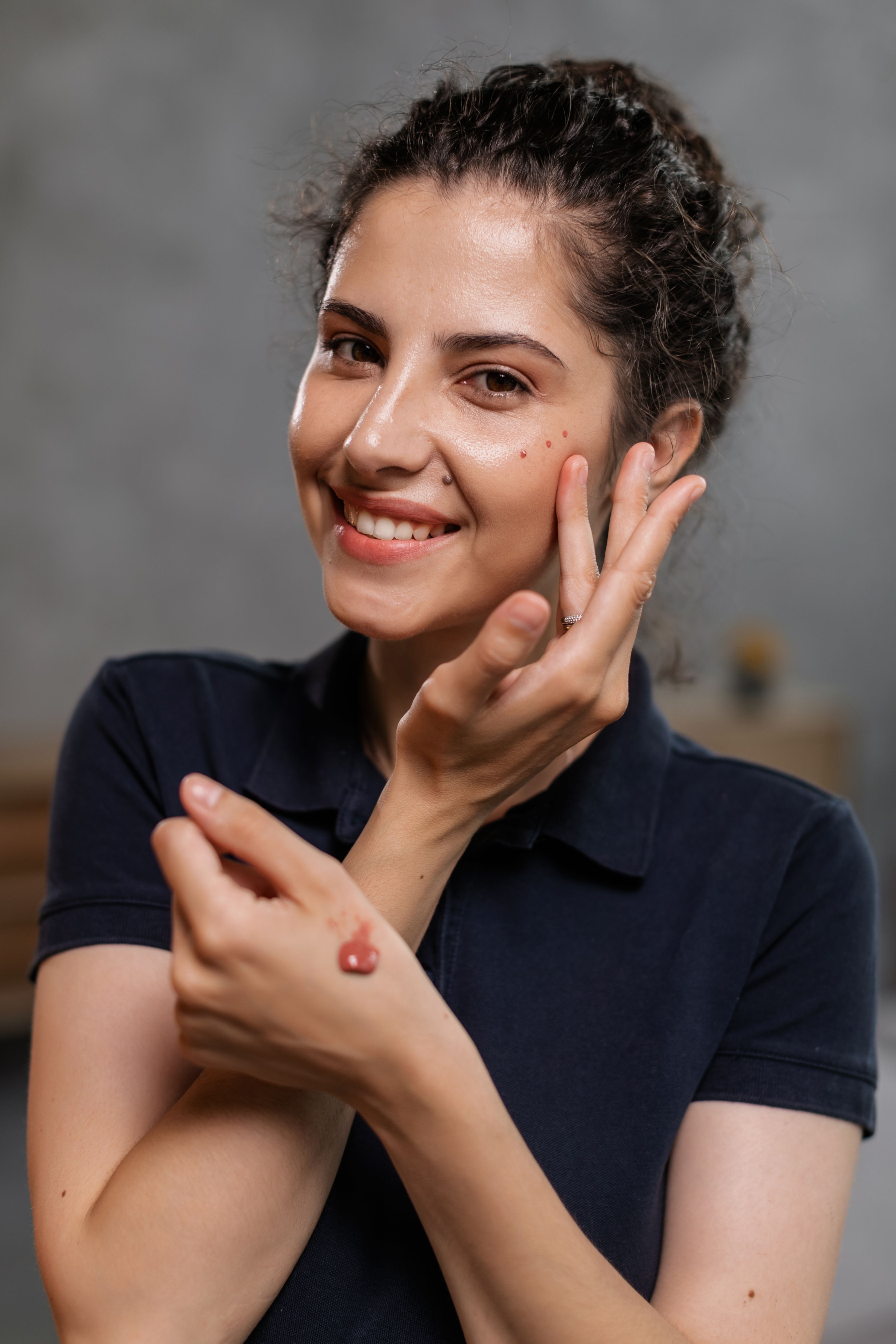 Woman applying natural makeup for a Clean Girl beauty routine